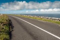 Small asphalt road by Atlantic ocean, Burren National geo park, Ireland. Nobody, Warm sunny day. Beautiful cloudy blue sky. Part Royalty Free Stock Photo