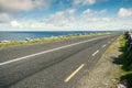 Small asphalt road by Atlantic ocean, Burren National geo park, Ireland. Nobody, Warm sunny day. Beautiful cloudy blue sky. Part Royalty Free Stock Photo