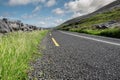 Small asphalt road by Atlantic ocean, Burren National geo park, Ireland. Nobody, Warm sunny day. Beautiful cloudy blue sky. Part Royalty Free Stock Photo