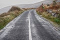 Small asphalt road by ocean. Burren area, Nobody. West of Ireland. Low cloudy sky. Transportation and tourism Royalty Free Stock Photo