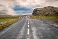 Small asphalt road on West coast of Ireland, part of Wild Atlantic Way route. Beautiful cloudy sky in the background, Rough stone Royalty Free Stock Photo