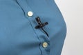 Small audio microphone for voice recording with a clothespin attached to a woman`s blue shirt