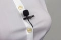 Small audio microphone for voice recording with a clothespin attached to a woman shirt