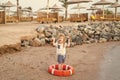 Small baby boy with happy face with lifebelt on beach