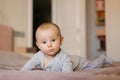 Small baby boy lying on stomach and raising his head while looking surprised, newborn Royalty Free Stock Photo