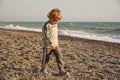 Small baby boy walking the seaside. the boy walks at sunset on the beach
