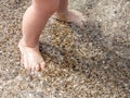 Baby feet close-up on the sand of the sea beach. Sea water washes the feet. Happy childhood. Rest at the sea. Summer Royalty Free Stock Photo