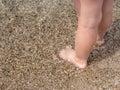 Baby feet close-up on the sand of the sea beach. Sea water washes the feet. Happy childhood. Rest at the sea. Summer Royalty Free Stock Photo