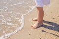 Baby feet close-up on the sand of the sea beach. Sea water washes the feet. Happy childhood. Rest at the sea. Summer Royalty Free Stock Photo