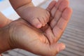 Small baby feet in the hands of man, family care, feet day, fathers day