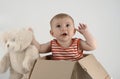 Small baby girl in a box with teddies