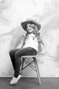 Small happy baby girl in cowboy hat on orange chair Royalty Free Stock Photo