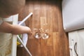 A small baby on a high chair dropped a cup of noodle soup on the wooden floor. The transparent plate is divided into two