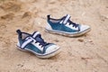 Small baby shoes on the sand. Empty kids sneakers on beach. Summer vacation. Royalty Free Stock Photo