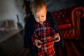 Small baby is standing and holding tablet in hands. He is looking at it. Child is concentrated Royalty Free Stock Photo