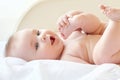 Small baby sucking her fingers on the leg Royalty Free Stock Photo