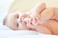 Small baby sucking her fingers on the leg Royalty Free Stock Photo