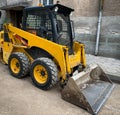 Small backhoe loader parked on a construction site. Royalty Free Stock Photo