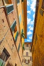 Small backstreet under a blue sky with clouds in Siena Royalty Free Stock Photo