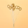 Small bagels on ropes fly up on a yellow background. The concept of bagels like balloons.