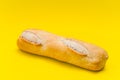 Small baguete of french bakery bread on a pure yellow surface Royalty Free Stock Photo