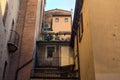 Small balcony with potted plants fitted in a shady alley in an italian town at sunset
