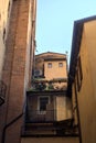 Small balcony with potted plants fitted in a shady alley in an italian town at sunset