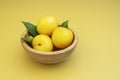 A small bamboo wooden bowl filled with large ripe yellow plums Royalty Free Stock Photo