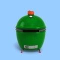 Small barbecue green color BBQ grill for outdoor prepare meat food front view 3d render on blue