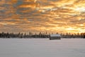 Small barn house covered with snow under the dramatic skies