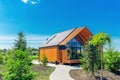 Small barnhouse house on a plot with a path, trees and bushes under a blue sky Royalty Free Stock Photo