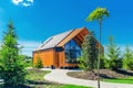 Small barnhouse house on a plot with a path, trees and bushes under a blue sky Royalty Free Stock Photo