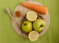 Small basket with fruits. Apples, lemons, carrot on the table.