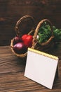 Small basket with organic products, fresh vegetables. Cucumber, garlic, onion, avocado and parsley on wooden background with copy