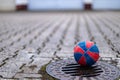 Small basketball for children lying on a gully cover in a deserted backyard