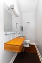 A small bathroom with a floating wood cabinet and stainless steel sink.