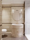 A small bathroom with a shower and toilet and ceramic tiles on the walls and floor is beige