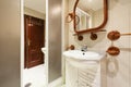 A small bathroom with a white wooden cabinet with drawers, k with a marble top, a wooden framed mirror and matching Royalty Free Stock Photo