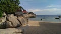 Small beach, big limestones and some Buildings close to the Ocean. Holidays on the Island Koh Tao.