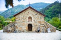 Small beautiful church in Bulgaria in the mountain. Green hills with forests and trees behind it. Royalty Free Stock Photo