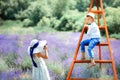 Small beautiful curly blonde girl photographer take picture of 6 years old boy in lavender field. Childhood close to nature. Royalty Free Stock Photo