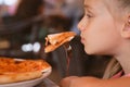 A small beautiful girl hand holding a slice of Pizza in Restaurant Royalty Free Stock Photo