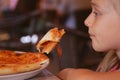 A small beautiful girl hand holding a slice of Pizza in Restaurant Royalty Free Stock Photo