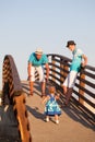 Small beautiful pretty girl is walking on wooden bridge to his father. Royalty Free Stock Photo