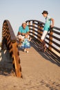 Small beautiful pretty girl is walking on wooden bridge to his father. Royalty Free Stock Photo