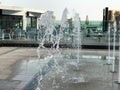 A small beautiful singing fountain in the open air, on the street. Drops of water, jets of water frozen in the air in flight again Royalty Free Stock Photo