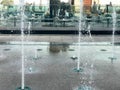 A small beautiful singing fountain in the open air, on the street. Drops of water, jets of water frozen in the air in flight again Royalty Free Stock Photo