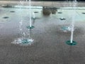 A small beautiful singing fountain in the open air, on the street. Drops of water, jets of water frozen in the air in flight again Royalty Free Stock Photo