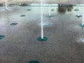 A small beautiful singing fountain in the open air, on the street. Drops of water, jets of water frozen in the air in flight again Royalty Free Stock Photo