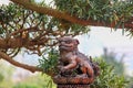 Small beautiful statue of mythical chinese lion guard on blurred pine tree background in Chi Lin Nunnery park,Hong Kong. Royalty Free Stock Photo